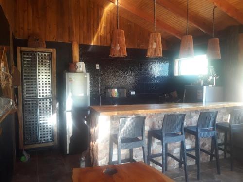 SalamancaAlto Ciprés的厨房配有带椅子的酒吧和冰箱
