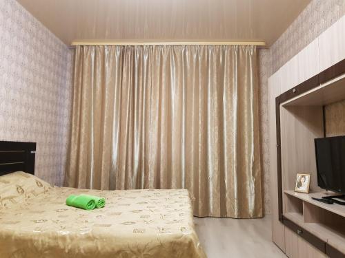 苏尔古特Улучшенные апартаменты на Ауре的一间卧室配有一张带绿瓶的床