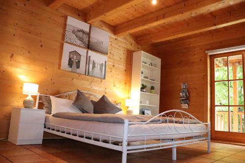 基姆湖畔贝尔瑙Studio im Blockhaus am Chiemsee的卧室配有木墙内的一张床