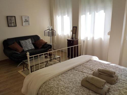 波尔图Made in You - Oporto Guesthouse的一间卧室配有一张床、一把椅子和一张沙发