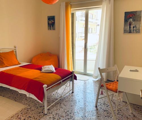 马科普隆Small Apartment in Markopoulo center的一间卧室配有一张床、一个窗口和一张书桌