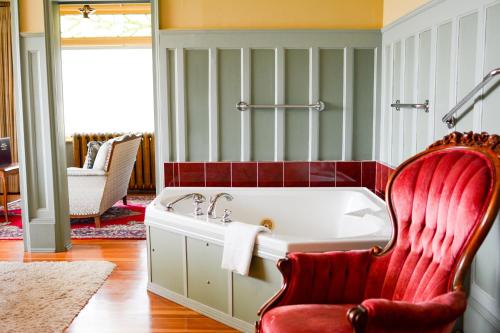 维多利亚达什伍德庄园海滨住宿加早餐酒店的带浴缸和红色椅子的浴室