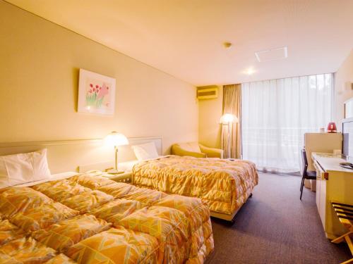 挂川市TSUMAGOI度假村 彩乡的酒店客房配有两张床和一张书桌