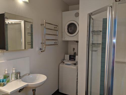 奥尔巴尼Hanover Bay Apartments的白色的浴室设有水槽和淋浴。