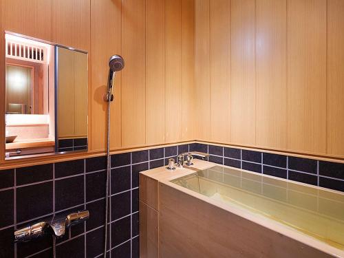 会津若松庄助の宿瀧の湯日式旅馆的一间带水槽和镜子的浴室