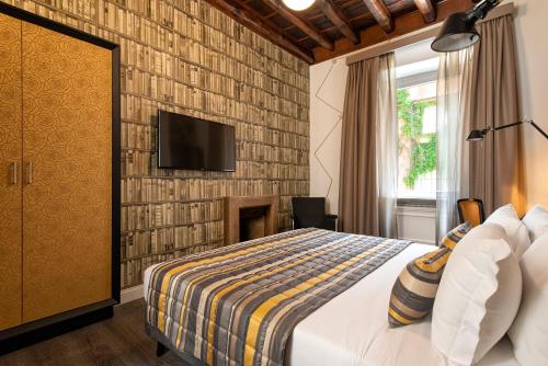 罗马埃维莉娜旅馆的卧室配有1张床和1台砖墙电视
