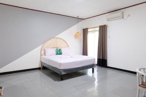 班达楠榜Rarem Bed & Breakfast的一间白色客房内的床铺卧室