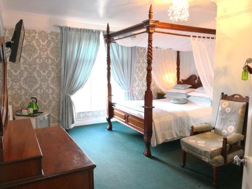 圣奥斯特尔拱门住宿加早餐酒店的一间卧室配有一张天蓬床和一把椅子