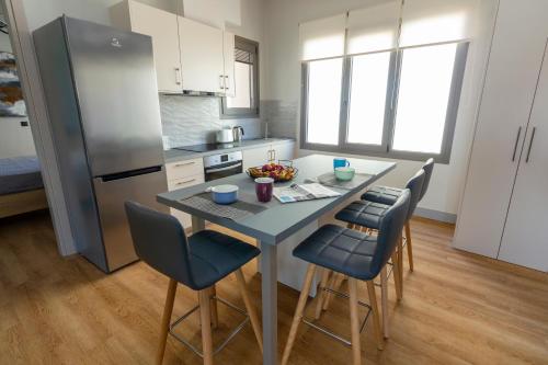 海若克利欧Heraklion chic and minimalistic apartment with sea view的厨房配有桌椅和冰箱。