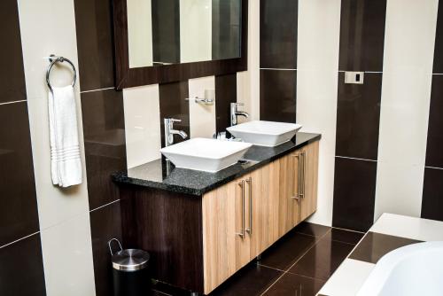 波罗瓜尼红宝石精品酒店的浴室设有2个水槽和镜子