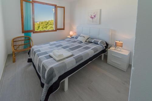 阿雷纳尔登卡斯特尔Vistas al mar y la piscina的一间卧室设有一张大床和窗户