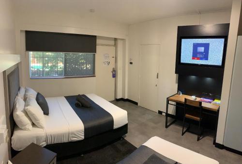 凯瑟琳The Stuart Hotel-Motel的酒店客房配有一张床、一张书桌和一台电视。