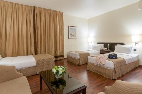贝鲁特乐可摩德酒店的酒店客房设有两张床和一张桌子。