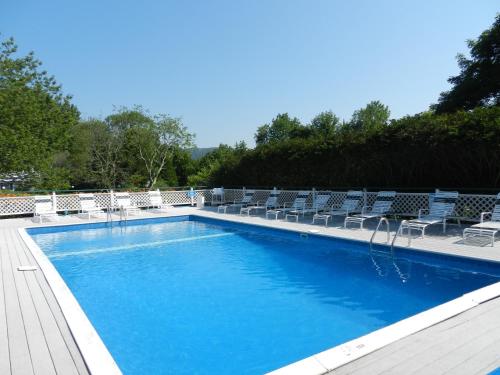 卡姆登锡达克雷斯特酒店的一个带椅子的大型蓝色游泳池