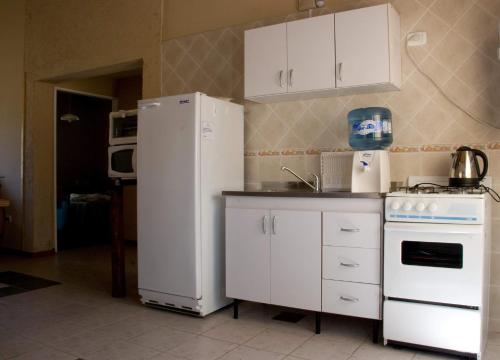 且乌塔Aguilas de Piedra的厨房配有白色冰箱和炉灶。