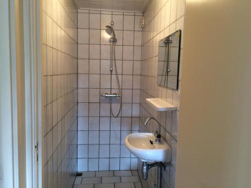 比伦B&B Nobel的白色瓷砖浴室设有水槽和淋浴
