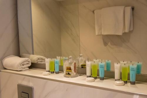 利马索尔佩弗克斯城市酒店的浴室设有1个带蜡烛和镜子的架子