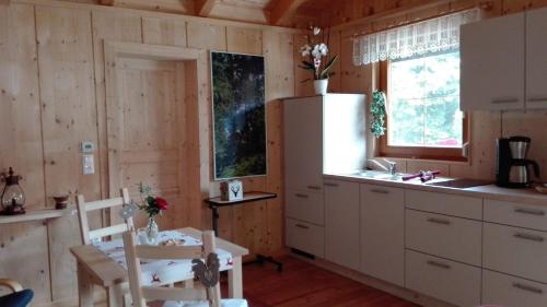 EbenthalFerienhaus Barbara的厨房配有白色橱柜和桌椅