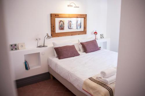 米尔芳提斯城Casa do Lado的一间卧室配有带白色床单和棕色枕头的床。