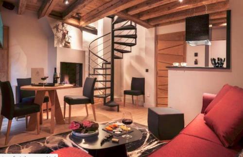 安锡阿纳西维埃耶威乐旅馆的一间带红色沙发的客厅和螺旋楼梯