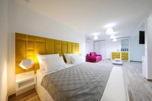 比比涅Boutique Residence Cosmopolis 1的一间卧室配有一张大床和一张粉红色的椅子