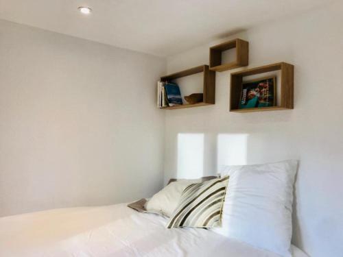 代米考迪亚Appartement cosy et chaleureux à Megève avec vue sur le Mont Blanc的卧室配有一张床铺,墙上有两个架子