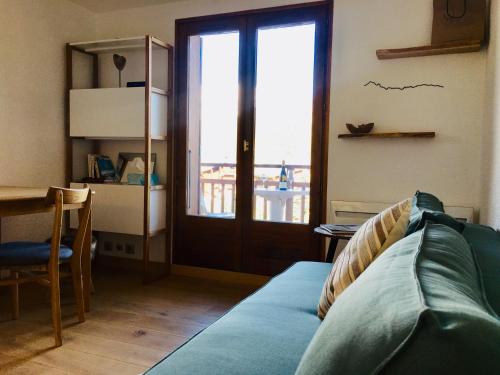 代米考迪亚Appartement cosy et chaleureux à Megève avec vue sur le Mont Blanc的带沙发和窗户的客厅