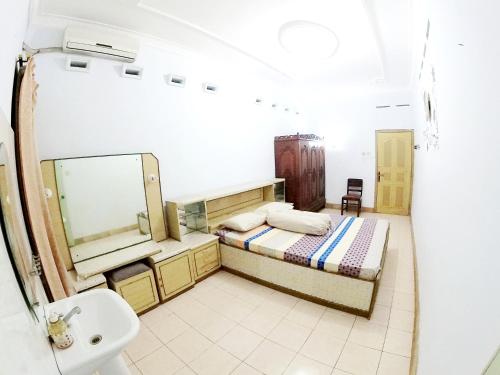 日惹With Friends Homestay Jogja的浴室设有床、水槽和镜子