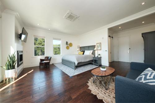 纳帕The Setting Inn Napa Valley的一间卧室设有一张床和一间客厅。