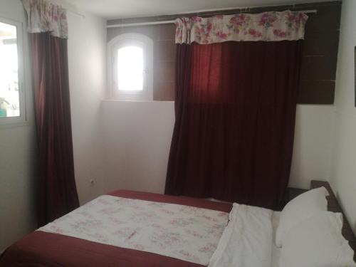 埃尔哈豪拉Miramar的一间卧室配有一张带红色窗帘的床和一扇窗户