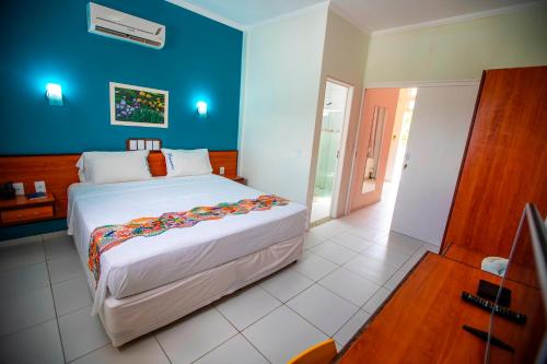 拉巴拉德纳圣米格尔Brisamar Hotel Pousada的一间卧室设有一张大床和蓝色的墙壁