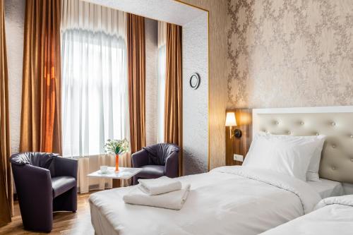 第比利斯Ornament Hotel的酒店客房配有一张床、两把椅子和一张桌子