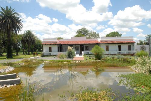 Rosario de LermaHotel Cerros的前面有池塘的房子
