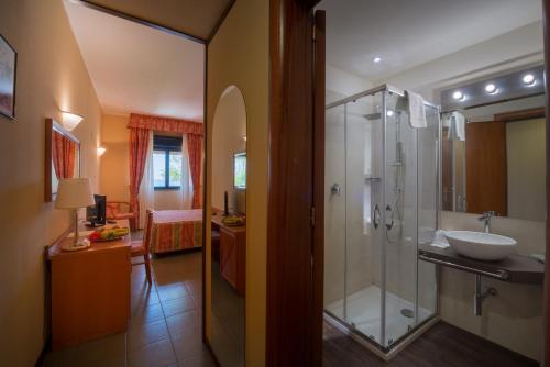 奇尼斯TH Cinisi - Florio Park Hotel的一间带玻璃淋浴和水槽的浴室
