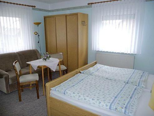 费茨肖马基斯膳食公寓酒店的卧室配有1张床、1张桌子和1把椅子