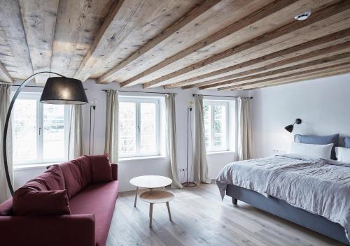 因斯布鲁克Faktorei的一间卧室配有一张床、一张沙发和窗户。