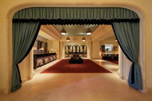 拉斯维加斯NoMad Las Vegas的通往客厅的开放式门廊,客厅配有蓝色窗帘