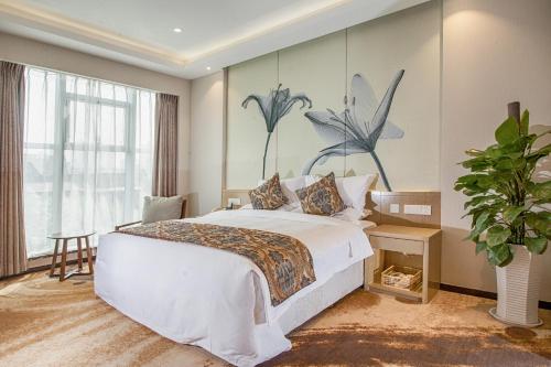 西安西安和平门精品酒店的卧室配有一张大床,墙上挂有绘画作品