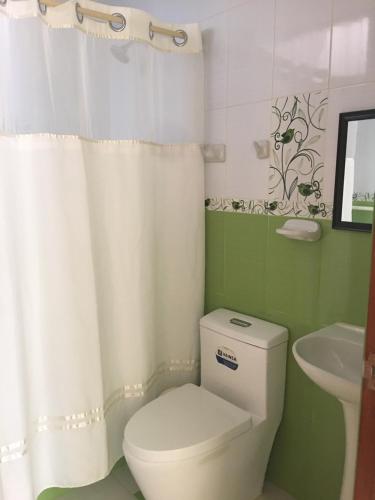 卢那欢纳LA CASA BLANCA的浴室配有白色卫生间和盥洗盆。