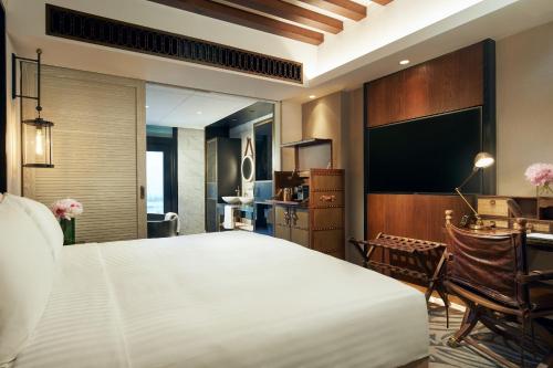 新加坡The Barracks Hotel Sentosa by Far East Hospitality的一间酒店客房,配有一张大床和一台平面电视