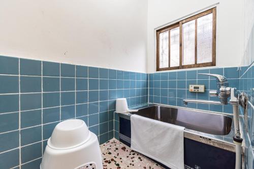 大阪Chachamaru Osaka Castle Park的浴室铺有蓝色瓷砖,设有水槽