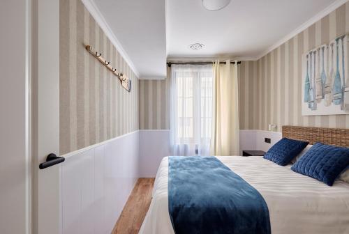 罗列特海岸"Breeze" Aparthotel by Parrot`s House的一间卧室配有一张带蓝色枕头的大床