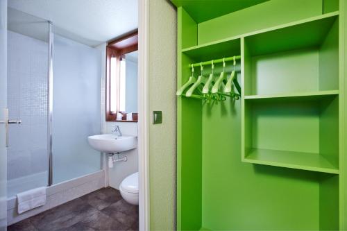 蒙蒂维利耶北勒阿弗尔 - 蒙特维尔钟楼酒店的浴室配有绿色的墙壁、卫生间和水槽。