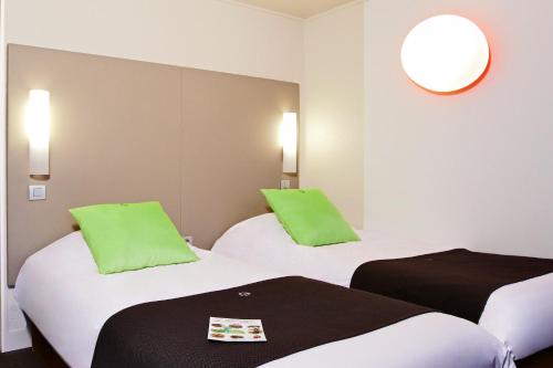 蒙蒂维利耶北勒阿弗尔 - 蒙特维尔钟楼酒店的酒店的客房 - 带两张带绿色枕头的床