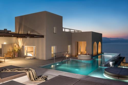 阿克罗蒂里Arota Exclusive Villas的夜间带游泳池的别墅