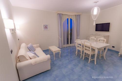 瓦斯托拜亚戴菲斯度假酒店的客厅配有白色的沙发和桌子