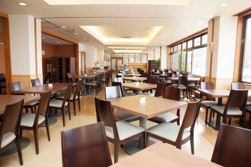 富士河口湖露樱酒店 河口湖的餐厅设有木桌、椅子和窗户。
