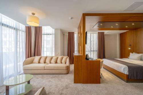 第比利斯Hotel Atlas Abashidze的酒店客房,配有床和沙发