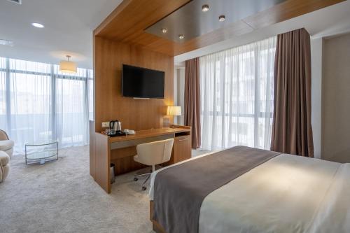 第比利斯Hotel Atlas Abashidze的配有一张床和一张书桌的酒店客房