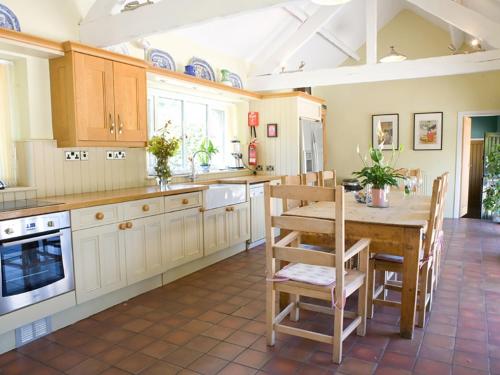 LlangristiolusOld Barns - Pentre Berw的一个带木桌和椅子的大厨房